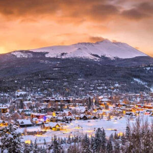 Thị trấn Breckenridge, Colorado phủ đầy tuyết trắng, với những ngôi nhà gỗ ấm cúng và những ngọn núi hùng vĩ phía sau.