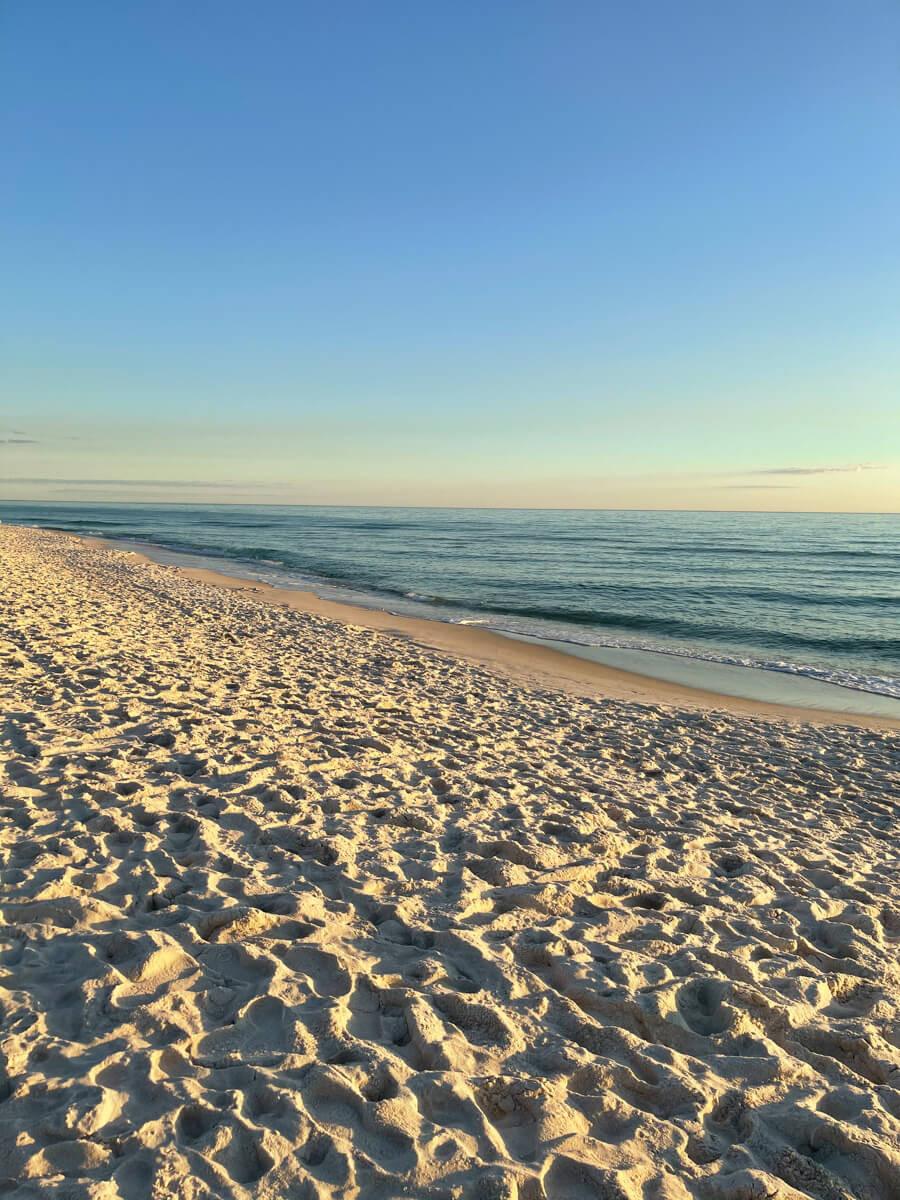 Một buổi chiều đầy nắng trên bãi biển ở Destin, Florida với cát trắng và biển xanh trong vắt