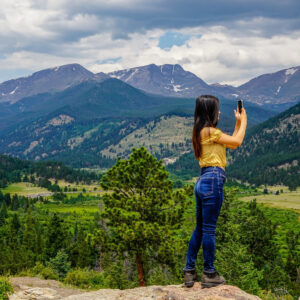 Người phụ nữ tạo dáng trên nền cảnh núi non hùng vĩ tại Công viên Quốc gia Rocky Mountain.