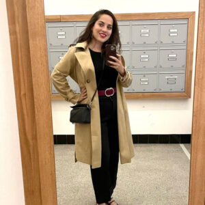 Một cô gái trẻ mặc áo khoác denim, đeo túi Marc Jacobs Snapshot, quần cargo satin và giày Cole Haan sneakers.