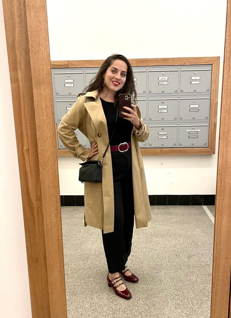 Một cô gái trẻ mặc áo khoác denim, đeo túi Marc Jacobs Snapshot, quần cargo satin và giày Cole Haan sneakers.