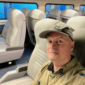 Du khách Matthew Kessi tạo dáng chụp ảnh selfie trên tàu Amtrak, thể hiện sự thích thú với chuyến đi và cảnh quan xung quanh.