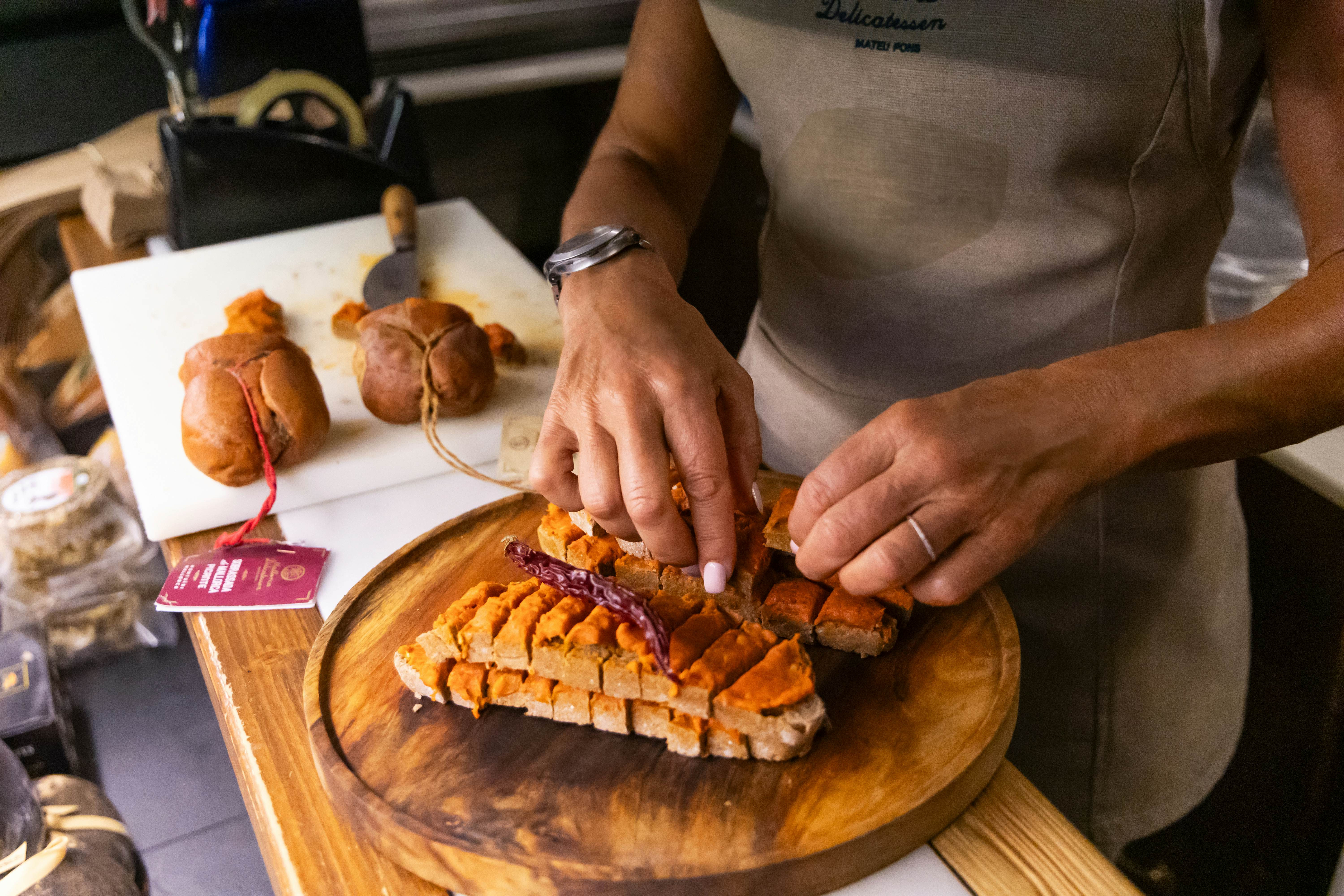 Một người bán hàng chuẩn bị các lát sobrasada, một loại xúc xích khô truyền thống của Mallorca, tại một khu chợ địa phương ở Palma de Mallorca. BIT 2025