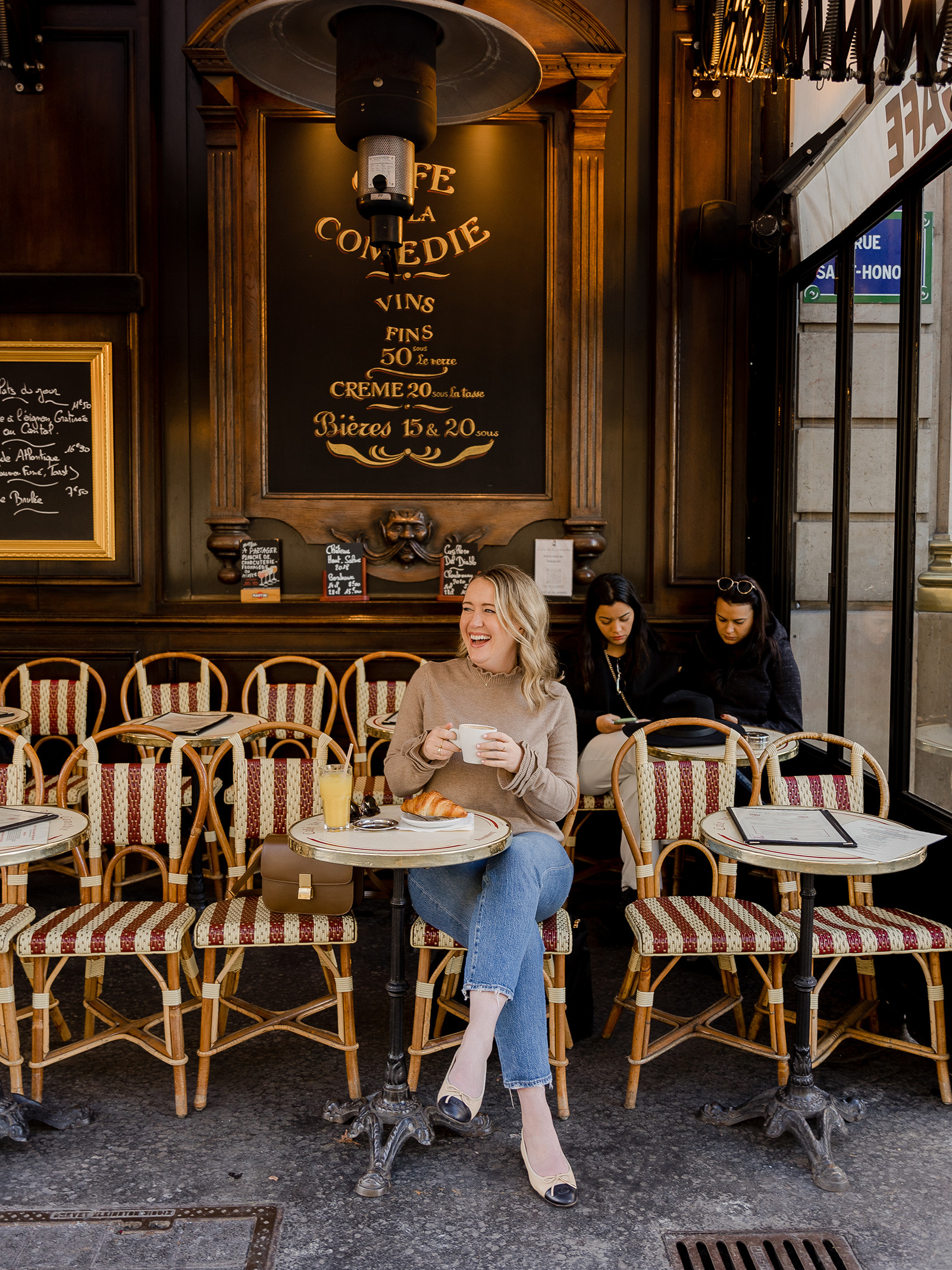 Ảnh chụp người phụ nữ đang ngồi uống cafe tại Paris.