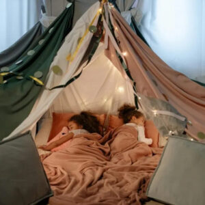 two young girls sleeping in a tent fort