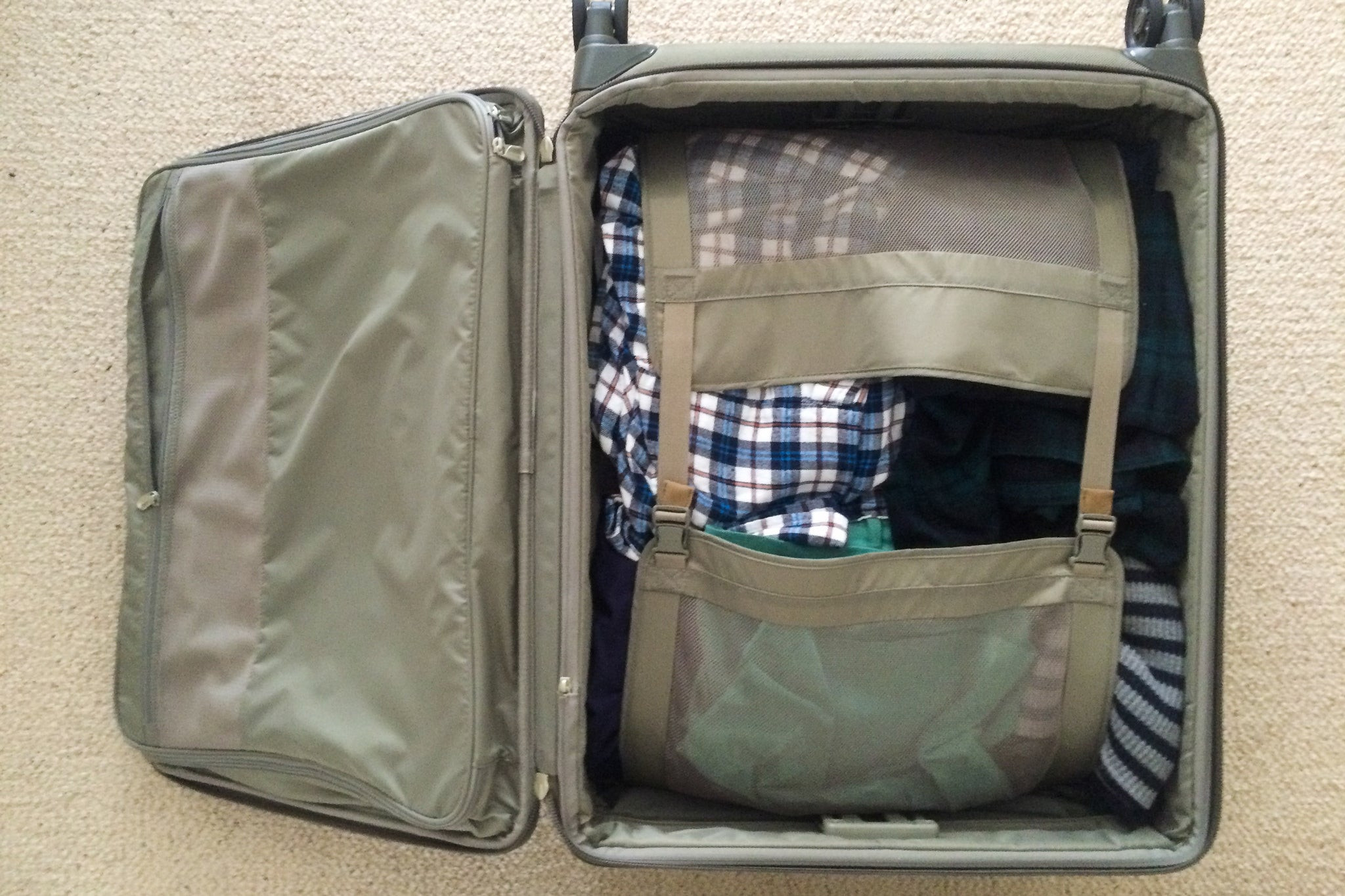 Quần áo gấp được cài khóa trong ngăn chính của Briggs & Riley Baseline Medium Expandable 25-inch Spinner.