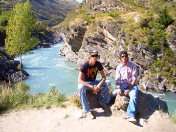 Tom và bạn của anh ấy ở New Zealand năm 2005, ngồi trên những tảng đá trước một dòng sông