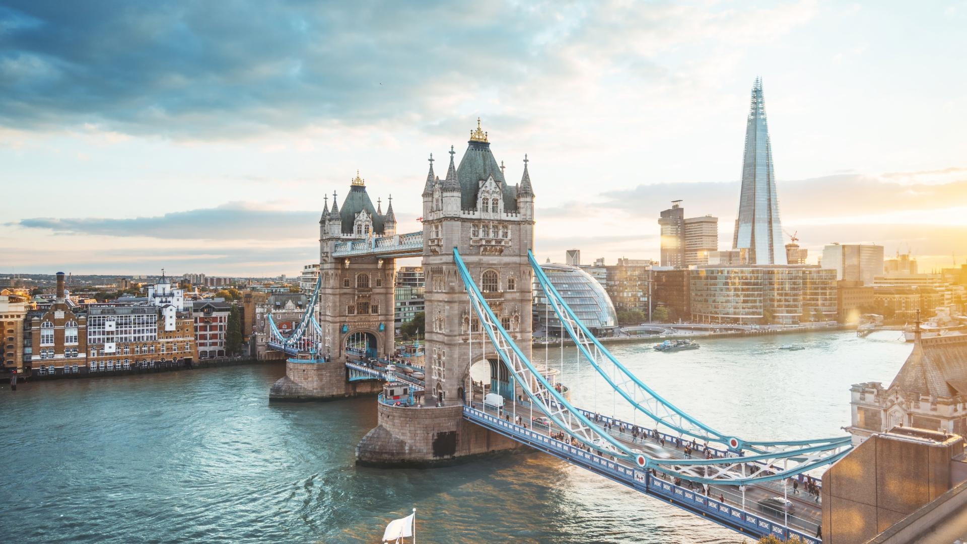 Cầu Tháp, London, vào giờ vàng với dòng xe cộ tấp nập và ánh đèn rực rỡ, tạo nên một khung cảnh đô thị sôi động và tráng lệ