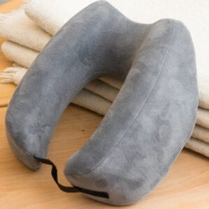 Gối du lịch Travelrest Nest Ultimate Memory Foam hình bánh donut vững chắc, đặt trên chăn.