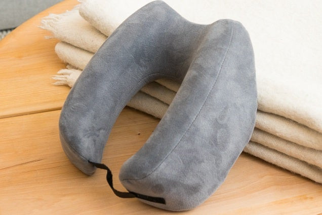 Gối du lịch Travelrest Nest Ultimate Memory Foam hình bánh donut vững chắc, đặt trên chăn.