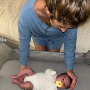 Người phụ nữ đặt em bé vào travel bassinet