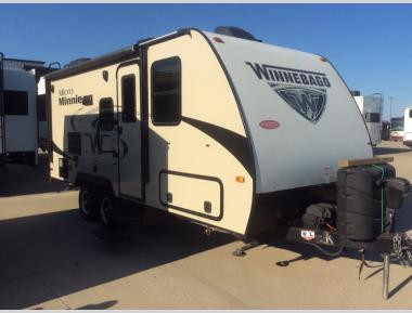 Winnebago Micro Minnie tại một khu cắm trại với khung cảnh thiên nhiên tươi đẹp.