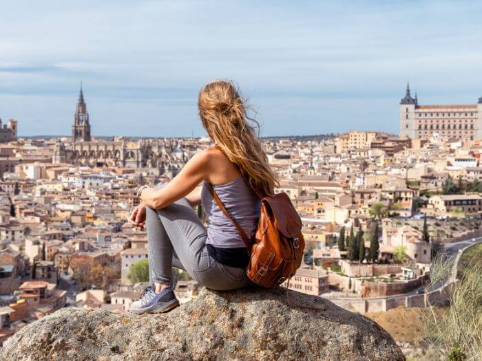 Một người phụ nữ ngồi trên tảng đá nhìn ra Toledo, Tây Ban Nha